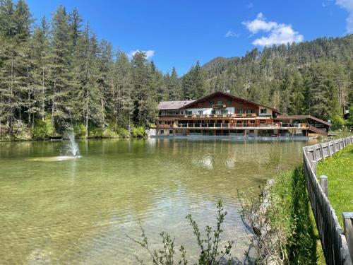 圣维吉利奥Hotel Lago della Creta的一座大型建筑,位于湖面上