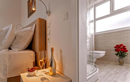 斯普利特Villa Zvonko的一间卧室设有一张床、一个窗口和一张带酒杯的桌子