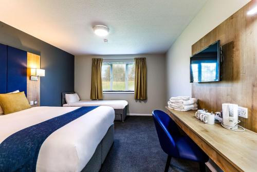 葛特纳格林戴斯格雷特纳格林酒店的酒店客房设有两张床、一张桌子和一台电视。