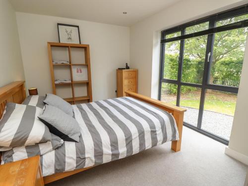 福丁布里奇Appletree Cottage的一间卧室设有一张床和一个大窗户