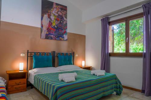 格罗塞托港Agriturismo Il Roseto的一间卧室配有一张带蓝色和绿色床单的大床
