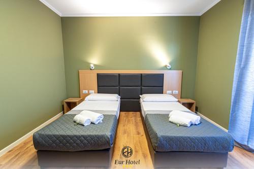 佛罗伦萨EURHOTEL的绿墙客房内的两张床