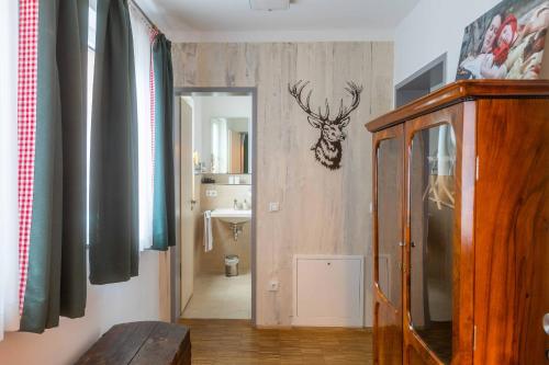 兰茨胡特Hotel Freischütz的走廊上设有浴室,墙上设有鹿头