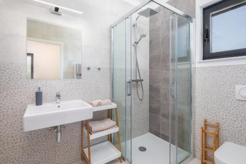 泽瑟沃Sun Resort Apartments的一间带水槽和玻璃淋浴的浴室