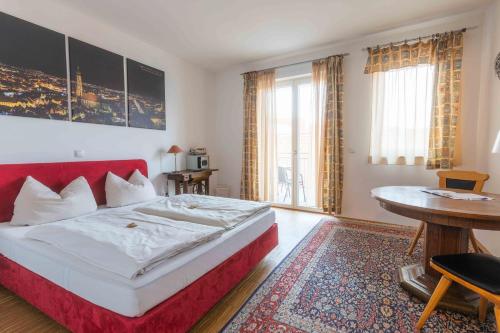 兰茨胡特Hotel Freischütz的一间卧室配有红色的床和一张桌子