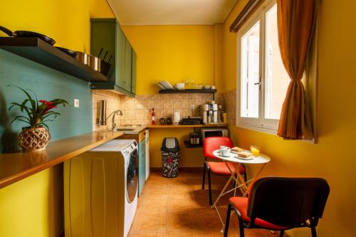 雅典Charlie city center room的厨房设有黄色的墙壁和桌椅