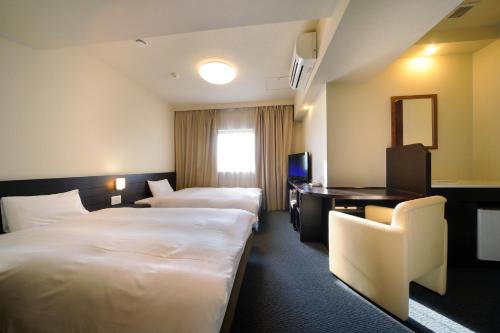 仙台多美迎仙台ANNEX酒店的酒店客房配有两张床和一张书桌
