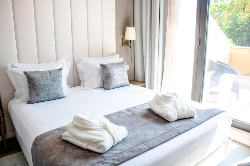 里斯本MASA Hotel & Spa Campo Grande Collection的带窗户的客房内的两张床和毛巾