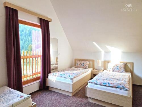 托波尔希卡Apartment HORTENZIJA near Terme Topolšica的带窗户的客房内的两张床