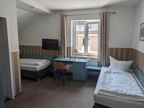 施韦特Parkhotel Schwedt的配有一张床和一张书桌的酒店客房