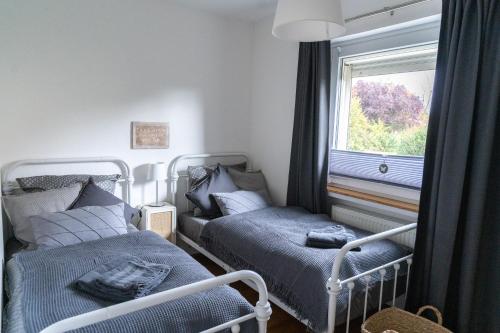 策勒Ferienwohnung Gartenkamp Celle的一间卧室设有两张床和窗户。