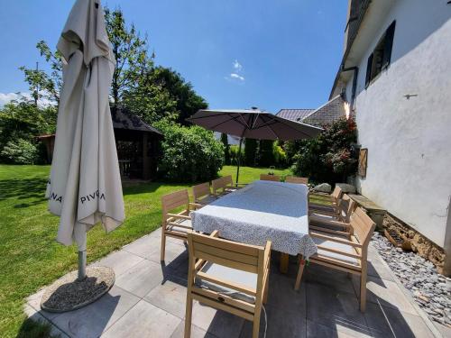 勒什Baroque villa near Bled - Resort Vidmar的庭院里配有桌椅和遮阳伞