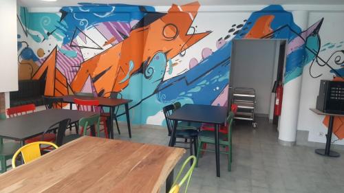 瓜尔达HI Guarda - Pousada de Juventude的配有桌椅和壁画的房间