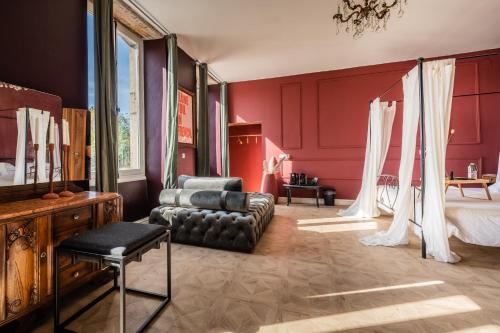 Melay迈洛伊酒庄住宿加早餐旅馆的卧室设有红色的墙壁、一张床和一张沙发
