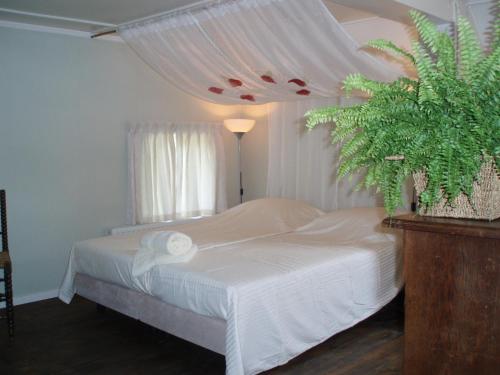 HerpenDe Erfdijk的卧室配有白色的床和植物