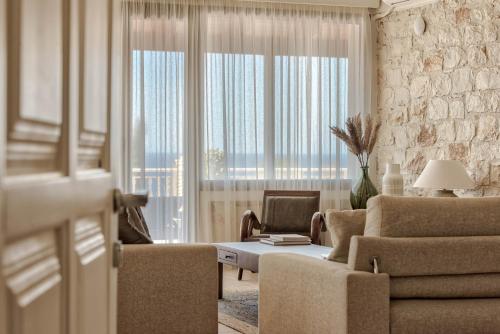 阿凯松阿南塔蓝色公寓的带沙发和椅子的客厅以及大窗户。