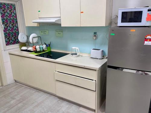 吉隆坡ARH Home KLCC的厨房配有水槽和冰箱