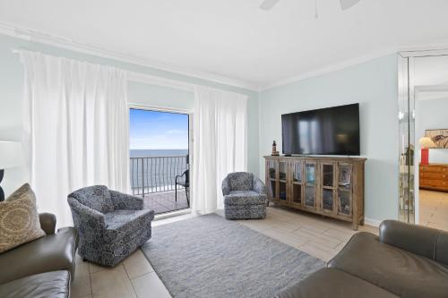 巴拿马城海滩Coral Reef Resort by Panhandle Getaways的客厅配有沙发、椅子和电视