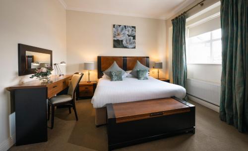 麦克鲁姆Castle Hotel Macroom的酒店客房配有一张床、一张书桌和一张书桌。