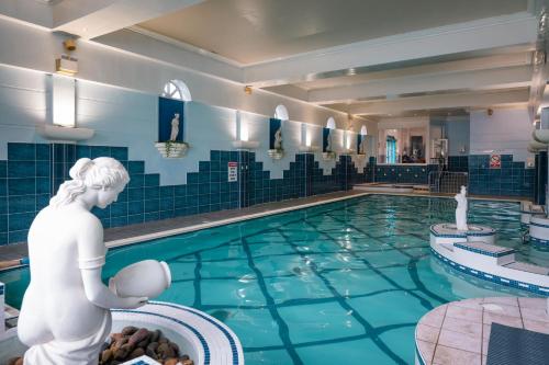 麦克鲁姆Castle Hotel Macroom的水中一个有女人雕像的游泳池