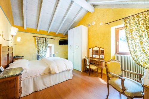 阿尔杰尼奥La Griglia HOTEL的卧室配有白色的床、书桌和窗户。