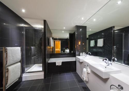 曼彻斯特曼彻斯特市政酒店的一间带两个盥洗盆和淋浴的浴室