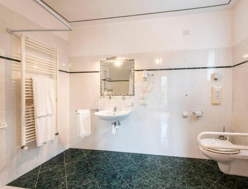 阿尔杰尼奥La Griglia Hotel的白色的浴室设有水槽和卫生间。