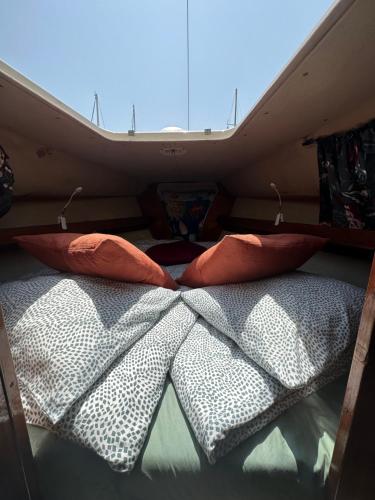 巴塞罗那Barco el viento的露营车后面的一张床铺,配有两个枕头