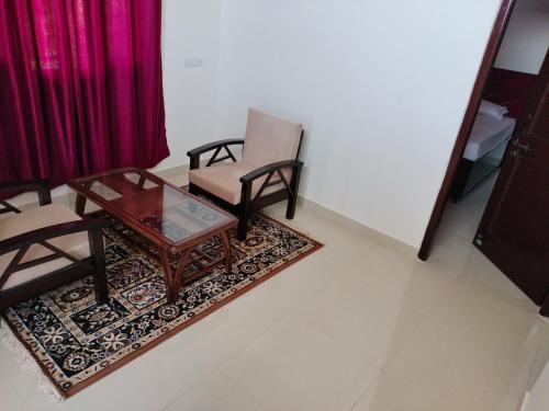 西姆拉Pal Homestay Shimla的客厅配有两把椅子和一张茶几