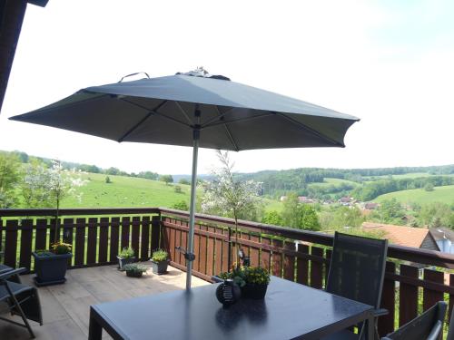 Ferienwohnung Traumblick的阳台上配有带雨伞的桌子