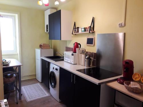 坎佩尔"Soleil" - appart étage 2 - Loc'h finistère - N6的厨房配有冰箱、洗衣机和烘干机