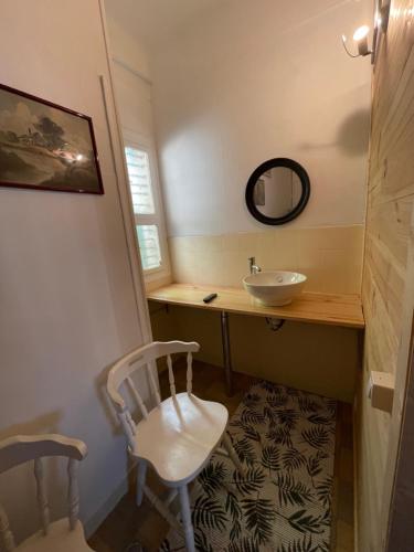 维特里勒弗朗索瓦Chez Léandre的一间带水槽、镜子和椅子的浴室