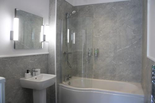 利物浦Fenwick Sunrise Hotel的带浴缸、水槽和淋浴的浴室