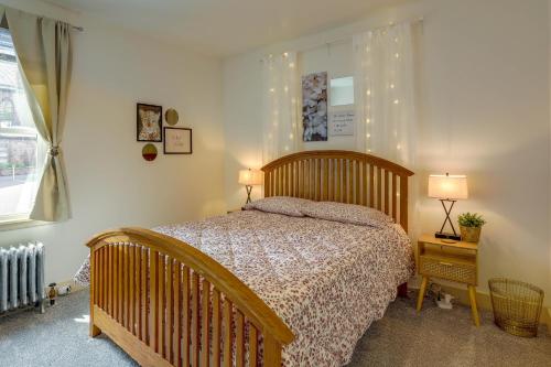 波茨敦Darling Pennsylvania Vacation Rental with Porch!的一间卧室配有一张床、两盏灯和一个窗户。