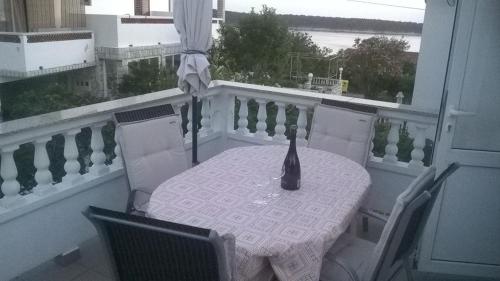 拉布Apartment Maria的阳台上的桌椅,上面有花瓶