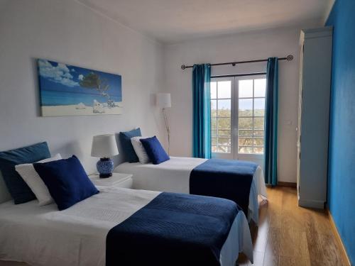 Figueira e BarrosVilla do Outeiro的酒店客房设有两张床和窗户。