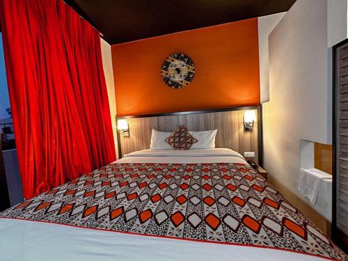 巴马科ONOMO Hotel Bamako的一间卧室配有一张带红色窗帘的大床