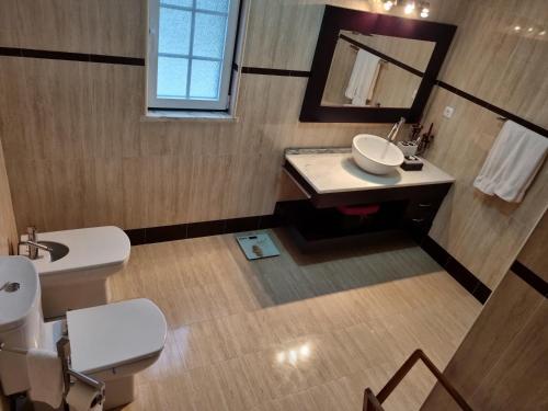 Figueira e BarrosVilla do Outeiro的一间带水槽、卫生间和镜子的浴室