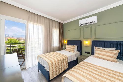 费特希耶IDEE SUİTES Fethiye的酒店客房设有两张床和一个阳台。
