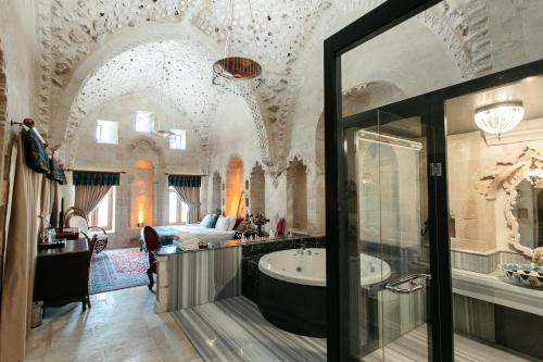 马尔丁马里丁酒店的一间带浴缸的浴室和一张位于客房内的床