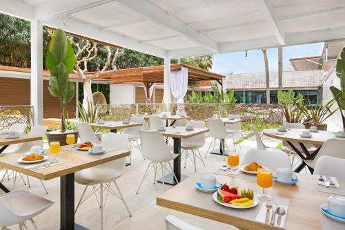 马尔格莱特德玛Sumus Hotel Monteplaya & SPA 4Sup - Adults Only的一间餐厅配有桌椅,提供食物