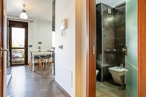 厄尔梅达诺Apartments Alba的带淋浴、卫生间和桌子的浴室