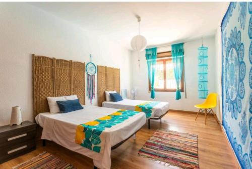 坎佩略CM Azibi Blue Room的一间卧室配有两张床和一张黄色椅子