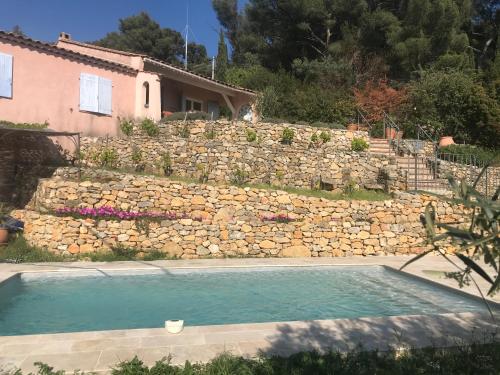 土伦Hauteurs de Toulon : Charmant studio piscine的一座带石墙和游泳池的房屋