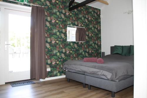 哈克斯卑尔根B&B Hoeve de Veldmaat的一间卧室配有一张带花卉壁纸的床