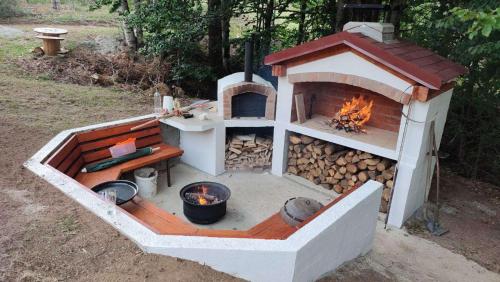 VerušaVikendica Verusa的一个带火坑和木柴的户外烤箱