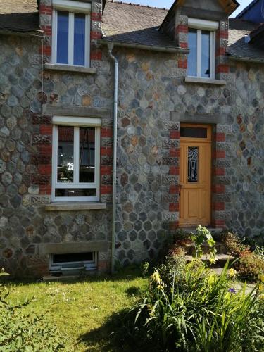 布列塔尼地区米尔Chambre d hôte chez Fany的砖房,有棕色的门和院子