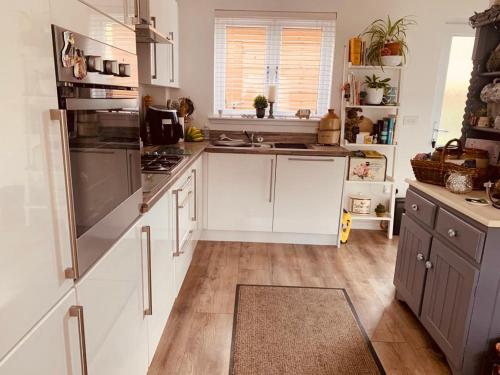 爱丁堡Home from home - Free Parking (near Edinburgh / Airport and Ingilston)的厨房配有白色橱柜和不锈钢用具