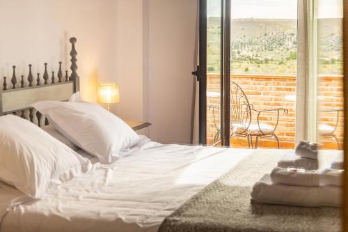 托莱多CASA RURAL Cigarral del Pintor的一间带白色床的卧室和一个阳台