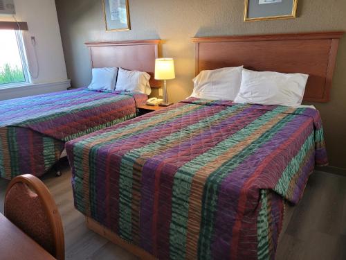 萨德伯里Canadiana Motel的酒店客房,设有两张床和一盏灯